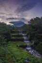 Merapi volcano with lenticular cloud on the peak of mountain with terraced waterfall