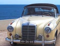 Pearlescent Mercedes Benz cabriolet convertible car in front of blue sea Royalty Free Stock Photo