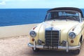 Pearlescent Mercedes Benz cabriolet convertible car in front of blue sea Royalty Free Stock Photo