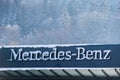 Mercedes Benz car brand logo on dealership showroom covered with snow. Royalty Free Stock Photo