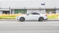 Mercedes-Benz CLA-Class C118 AMG Second generation, driving on the city street, side view. Modern city building at background