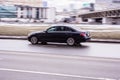 Mercedes-Benz E-class in the city street. Side view of black Mercedes car riding on the road on high speed Royalty Free Stock Photo