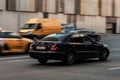 Mercedes-Benz E-Class W211 drive on the highway. Black sedan car moving on the street. Rear side view Royalty Free Stock Photo