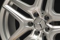 Mercedes Benz logo aluminum cast wheel, close-up, original silver wheel new in black background closeup