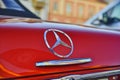 Mercedes Benz logo on a red vintage car. Close-up. Mercedes-Benz is a German automobile manufacturer. The brand is used Royalty Free Stock Photo