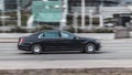 Mercedes-Benz S class in the city street in motion. Side view of black Mercedes premium car riding on the road on high speed Royalty Free Stock Photo