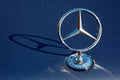 mercedes benz star mascot shining on the deep blue hood of an w123 oldtimer. ornament drop shadow on the metallic surface Royalty Free Stock Photo