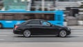 Mercedes E Class on the city road in motion. Fast speed drive on a street. Side view of moving black car with blurred urban Royalty Free Stock Photo