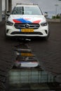 Mercedes police car on the street with a reflection on a puddle