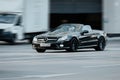 Mercedes SL 500 at the city road in motion. Black luxury car driving along the street in city, front side view Royalty Free Stock Photo