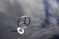 Mercedes star on a bonnet in which clouds reflect Royalty Free Stock Photo