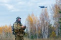 Mercenary soldier launch a reconnaissance drone in a forest.