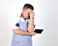 Merchant Asian man in white and blue apron is feeling regret or boring when get bad news from connection internet in tablet