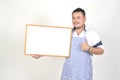 Merchant Asian man in white and blue apron to holding blank white broad for put some text or wording for present advertising Royalty Free Stock Photo