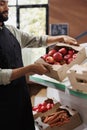 Merchant carrying box of apples in store Royalty Free Stock Photo