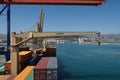 Merchant container ship with cranes moored in terminal is loading and discharging by gantry cranes operated by stevedores. Royalty Free Stock Photo