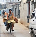 Merchant of household utensils carring his goods on a bicycle