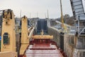 Merchant ship vessel with two cranes passing locks in the Great Lakes, Canada in winter time.