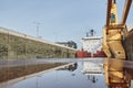 Merchant ship vessel with two cranes passing locks in the Great Lakes, Canada in winter time.