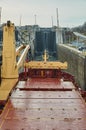 Merchant ship vessel with two cranes passing locks in the Great Lakes, Canada in winter time.