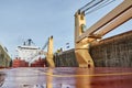 Merchant ship vessel with two cranes passing locks in the Great Lakes, Canada in winter time.