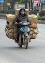 Merchant transports many boxes on the back of motorcycle.