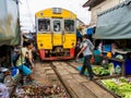 Merchants and the train at the Maeklong Railway Market in Bangkok, Thailand Royalty Free Stock Photo