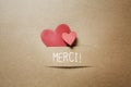 Merci - Thank you in French language with small hearts