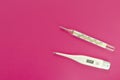 Mercury and digital thermometers on pink background
