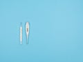 Mercury and electronic thermometers on a blue background