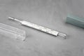 Mercury thermometer on a gray background near the case