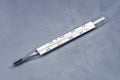 Mercury thermometer on a gray concrete background. Tinted blue