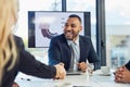 Merge and make it happen. a young businessman and businesswoman shaking hands during a meeting in a modern office. Royalty Free Stock Photo