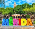 Colorful Merida sign with a Mexican flag and cathedral in the background in Merida, Mexico Royalty Free Stock Photo