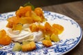 Meringue cake `Pavlova` with fresh yellow fruits and whipped cream Royalty Free Stock Photo