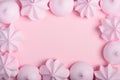 Meringue cookies frame. Sweet crispy twisted and drop meringue border on pink pastel background