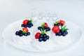 Meringue dessert Pavlova cake with fresh strawberries and blueberries with mint on the white plate with Love word Royalty Free Stock Photo