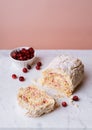 Meringue roll cake with cranberries on marble board Royalty Free Stock Photo