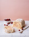 Meringue roll cake, fresh cranberries on marble board Royalty Free Stock Photo