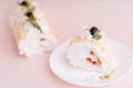 Meringue roll without sugar on white plate cut into pieces against pink background Royalty Free Stock Photo