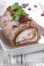 Meringue roulade with pecan nuts and cream cheese filling on the ceramic platter Royalty Free Stock Photo