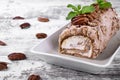 Meringue roulade with pecan nuts and cream cheese filling on the ceramic platter Royalty Free Stock Photo