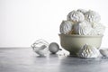 meringue in white plate, eggshell with whisk on gray table isolated on white with copy space