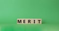Merit symbol. Concept word Merit on wooden cubes. Beautiful green background. Business and Merit concept. Copy space Royalty Free Stock Photo