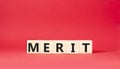 Merit symbol. Concept word Merit on wooden cubes. Beautiful red background. Business and Merit concept. Copy space Royalty Free Stock Photo