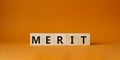 Merit symbol. Concept word Merit on wooden cubes. Beautiful orange background. Business and Merit concept. Copy space Royalty Free Stock Photo