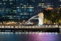 Merlion with skyscraper buildings in Singapore City at night. Financial district in downtown with business centers in technology