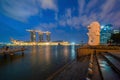 Merlion with skyscraper buildings in Singapore City at night. Financial district in downtown with business centers in technology