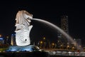 Merlion statue spraying the water from its mouth at Merlion Park in downtown core of Singapore at Marina Bay at at night time Royalty Free Stock Photo