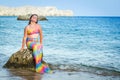 Mermaid girl posing on the beach rock